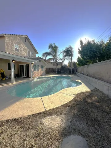 a view of a house with backyard and sitting area