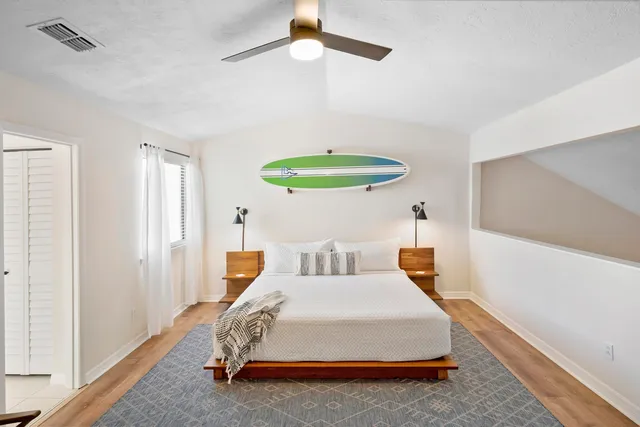 a bedroom with a bed a chandelier and a window