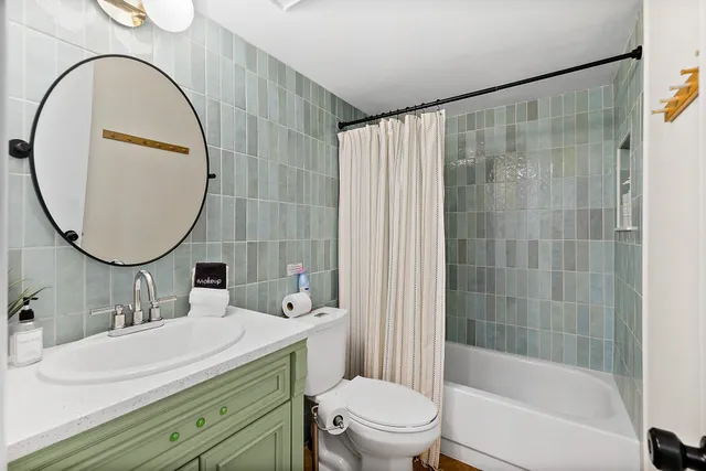 a bathroom with a sink a toilet a mirror and a shower