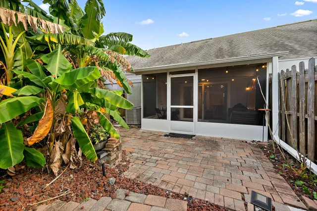 a backyard of a house with potted plants and large trees