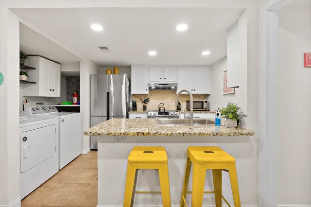 a kitchen with counter top space cabinets and appliances