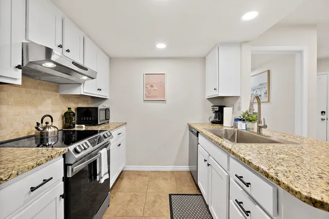 a kitchen with stainless steel appliances granite countertop a sink stove and cabinets