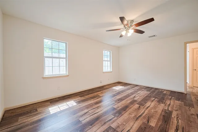 a view of empty room with wooden floor