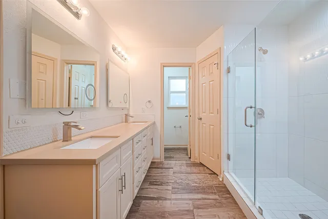 a bathroom with 2 sink and a mirror