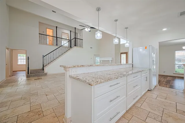 a spacious bathroom with a granite countertop sink a mirror and a bathtub