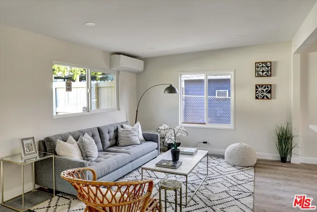 a living room with furniture a window and a potted plant
