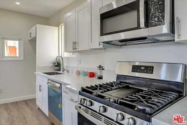 a kitchen with stainless steel appliances granite countertop a stove a microwave and cabinets