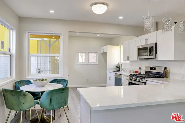 a kitchen with a dining table chairs and white appliances