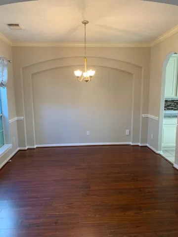 a view of a room with wooden floor and chandelier