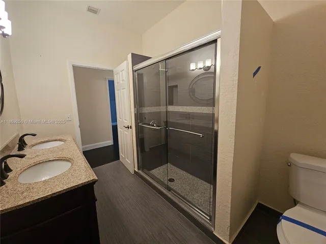 a bathroom with a granite countertop sink toilet and shower