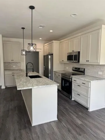 a open kitchen with a sink stove and wooden floor