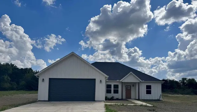 a front view of a house with yard and garage