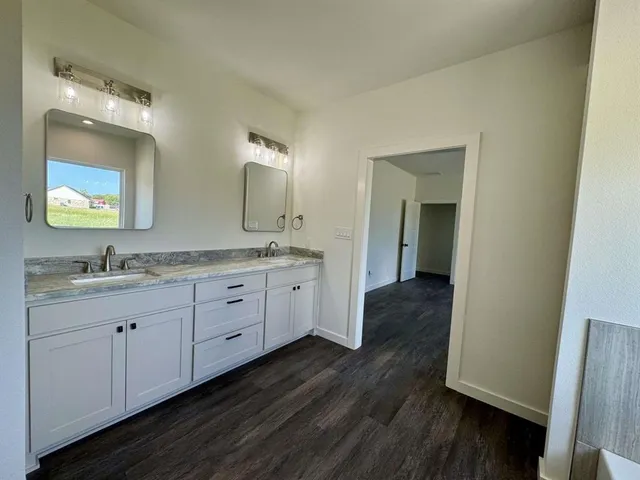 a spacious bathroom with a double vanity sink and a mirror
