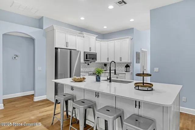 a kitchen with refrigerator and chairs