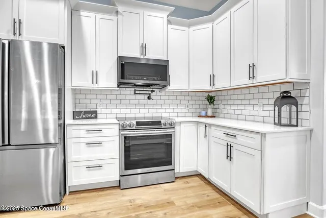 a kitchen with white cabinets stainless steel appliances and sink