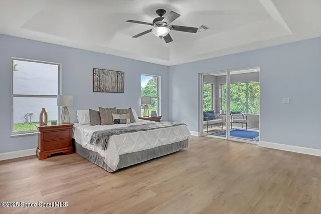 a spacious bedroom with a large bed and a chandelier