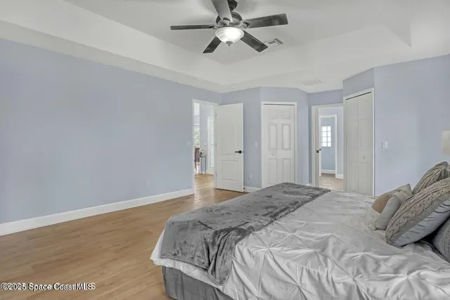 a bedroom with a bed and a ceiling fan