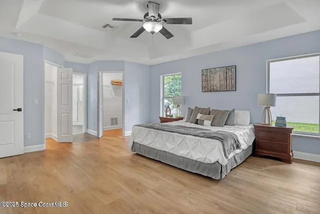 a spacious bedroom with a bed and a chandelier