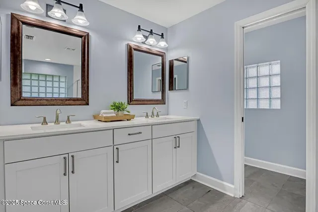 a bathroom with double vanity sink a vanity and a mirror
