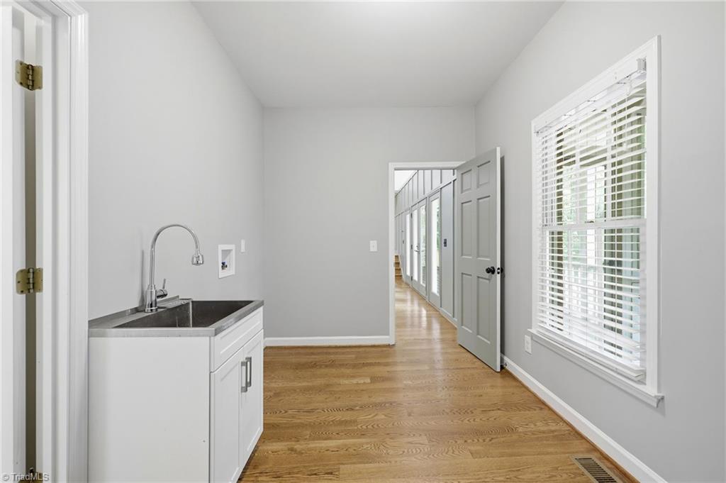 8861 Boylston Road Colfax, NC 27235 - Photo 24 of 50 Oversized laundry room with utility sink, exterior access to the screened porch (out of frame), and convenient interior access to the main living area.