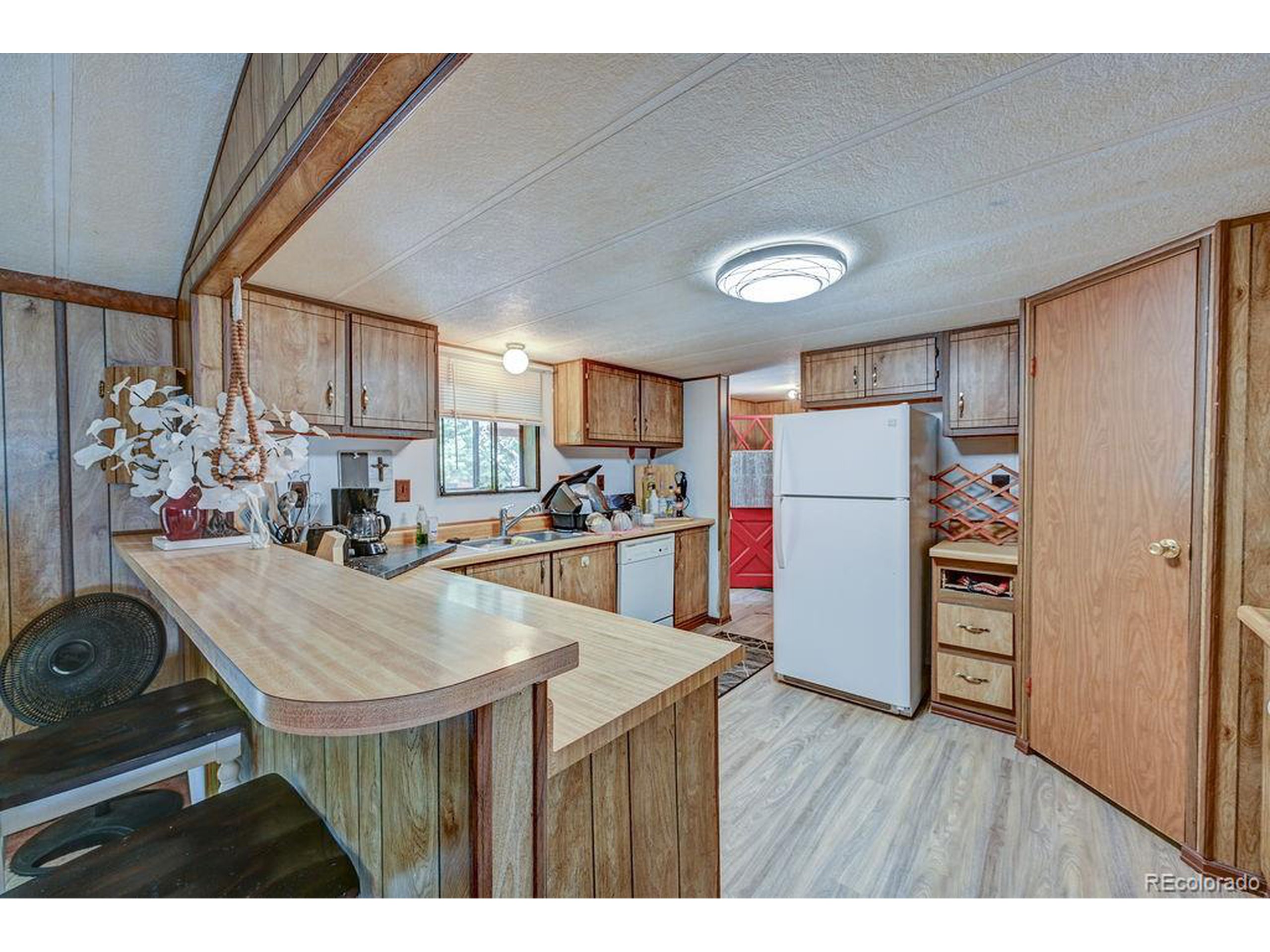 121 Brookdale Avenue Buena Vista, CO 81211 - Photo 38 of 50 a kitchen that has a lot of cabinets a refrigerator and wooden floor