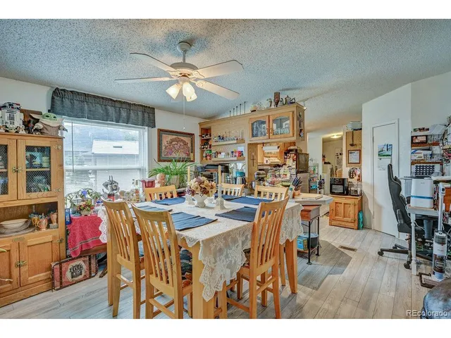a view of a dining room and livingroom with furniture wooden floor a rug a flat screen tv a rug and a chandelier