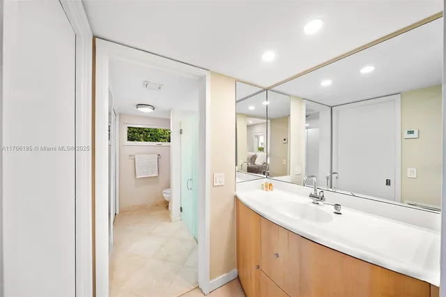 a bathroom with a granite countertop toilet a sink and a mirror