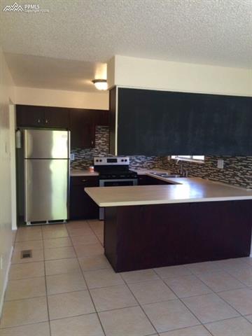 4415 Beaumont Road Colorado Springs, CO 80916 - Photo 13 of 29 View from the tiled dining area looking towards the kitchen.
