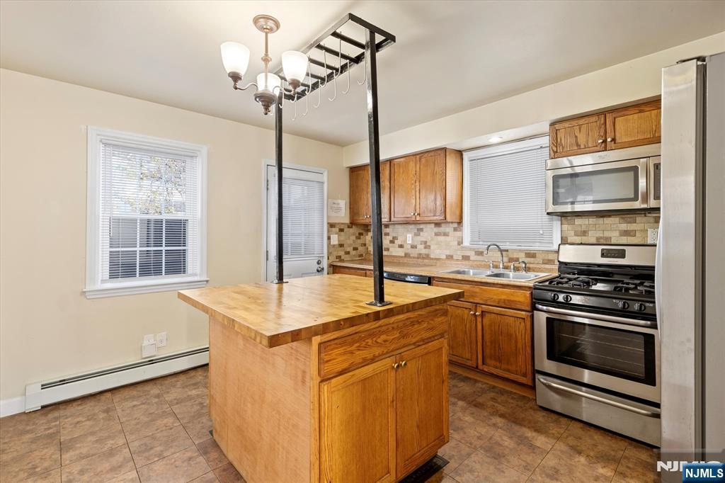 62 Johnson Avenue Wallington, NJ 07057 - Photo 5 of 25 a kitchen with stainless steel appliances granite countertop a sink stove and refrigerator