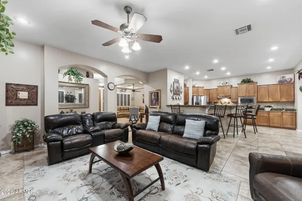 a living room with furniture kitchen view and a chandelier