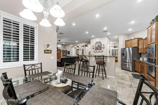 a room with stainless steel appliances a dining table wooden floor and a view of kitchen