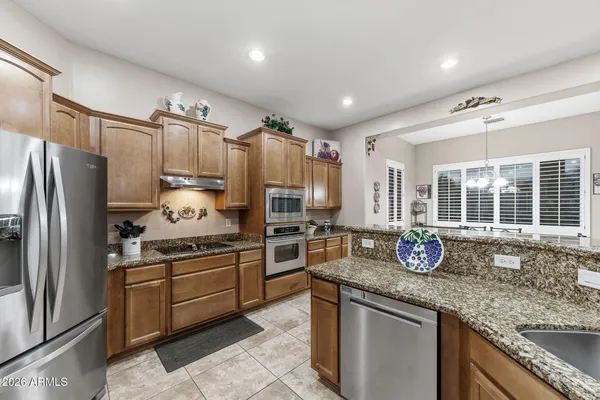 a kitchen with granite countertop a sink stainless steel appliances and cabinets