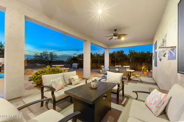 a living room with patio furniture and a large window