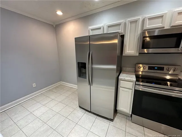 a metallic refrigerator freezer sitting in a kitchen