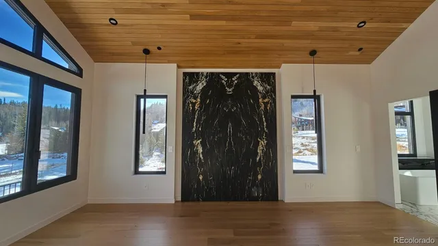 a view of a hallway with wooden floors and a window