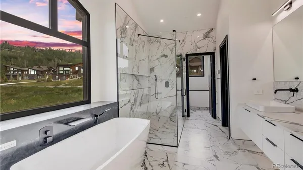 a bathroom with a tub a sink and glass door