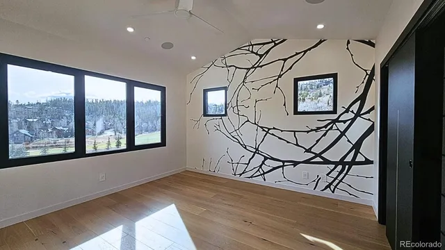 a view of a hallway with wooden floor and windows