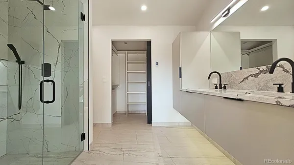 a bathroom with a double vanity sink a mirror and a shower