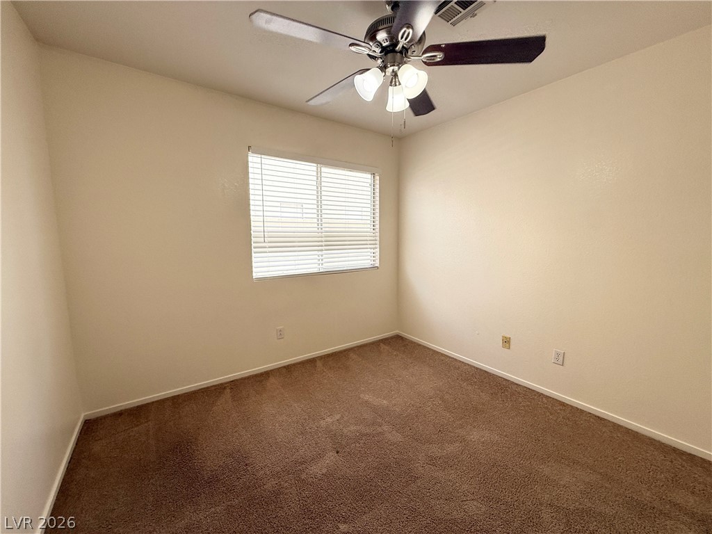 8870 Haviland Road Las Vegas, NV 89123 - Photo 21 of 24 An inviting room awaits with plush carpet, a wide window, and a cooling ceiling fan.