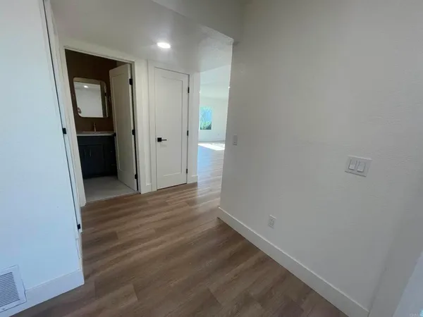 a view of a hallway with wooden floor