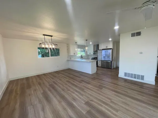 a view of a kitchen and an empty room
