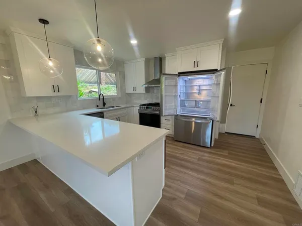 a kitchen with stainless steel appliances granite countertop a sink a oven and a large refrigerator