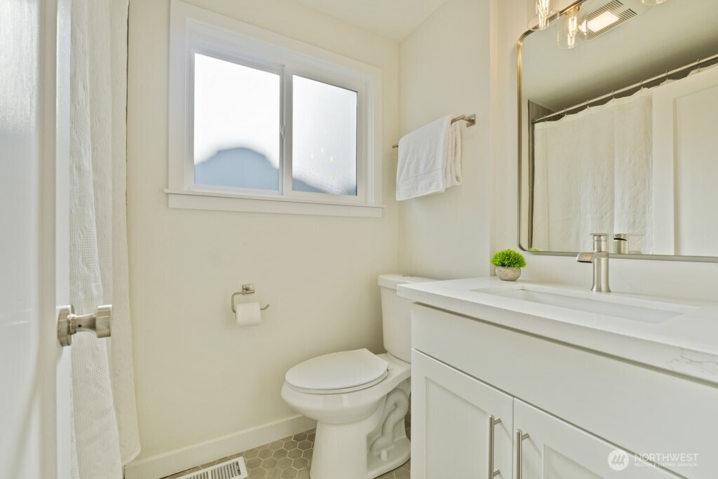 2646 34th Avenue West Seattle, WA 98199 - Photo 24 of 40 a bathroom with a granite countertop toilet sink and mirror