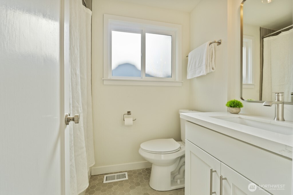 2646 34th Avenue West Seattle, WA 98199 - Photo 25 of 40 a bathroom with a granite countertop toilet sink and mirror