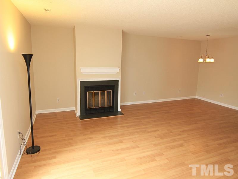 6705 Tattershale Court Raleigh, NC 27613 - Photo 6 of 13 Open living/dining rooms with attractive wood burning fireplace, new light fixture and laminate flooring.