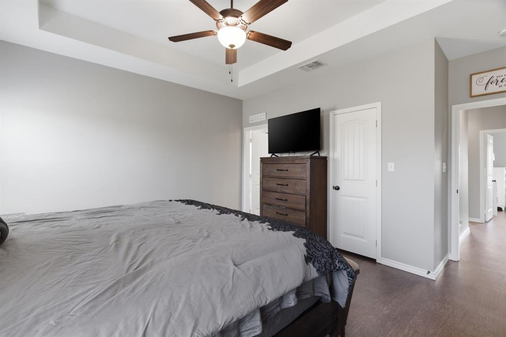 711 Hadley Lane Valley View, TX 76272 - Photo 16 of 40 Bedroom with a raised ceiling, ceiling fan, dark wood-type flooring, and a closet