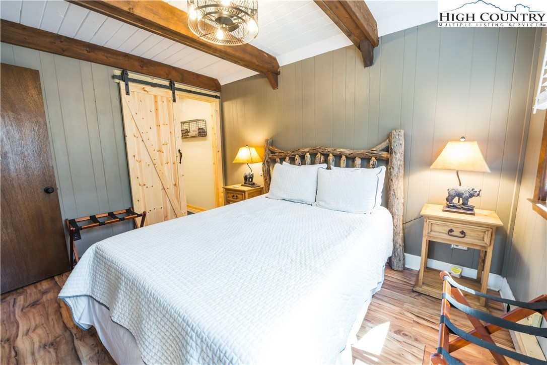 902 Pine Ridge Road Beech Mountain, NC 28604 - Photo 12 of 24 a bedroom with a bed and wooden floor