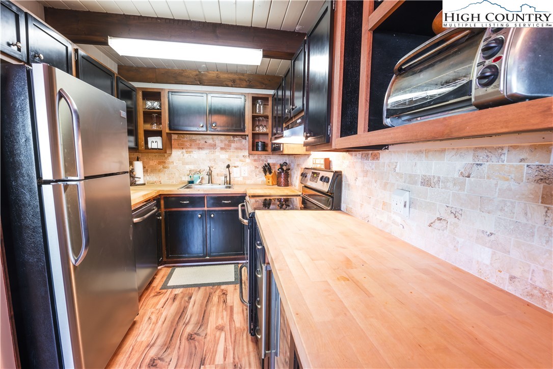 902 Pine Ridge Road Beech Mountain, NC 28604 - Photo 7 of 24 a kitchen with stainless steel appliances a refrigerator and a sink