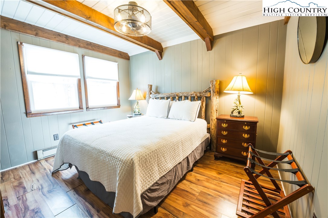 902 Pine Ridge Road Beech Mountain, NC 28604 - Photo 10 of 24 a bedroom with a bed a dresser and next to a window