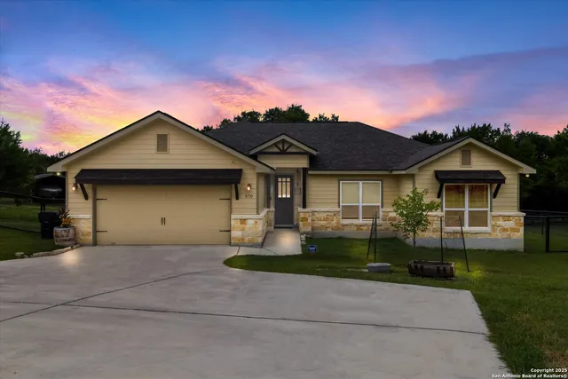 a front view of a house with a garden and yard